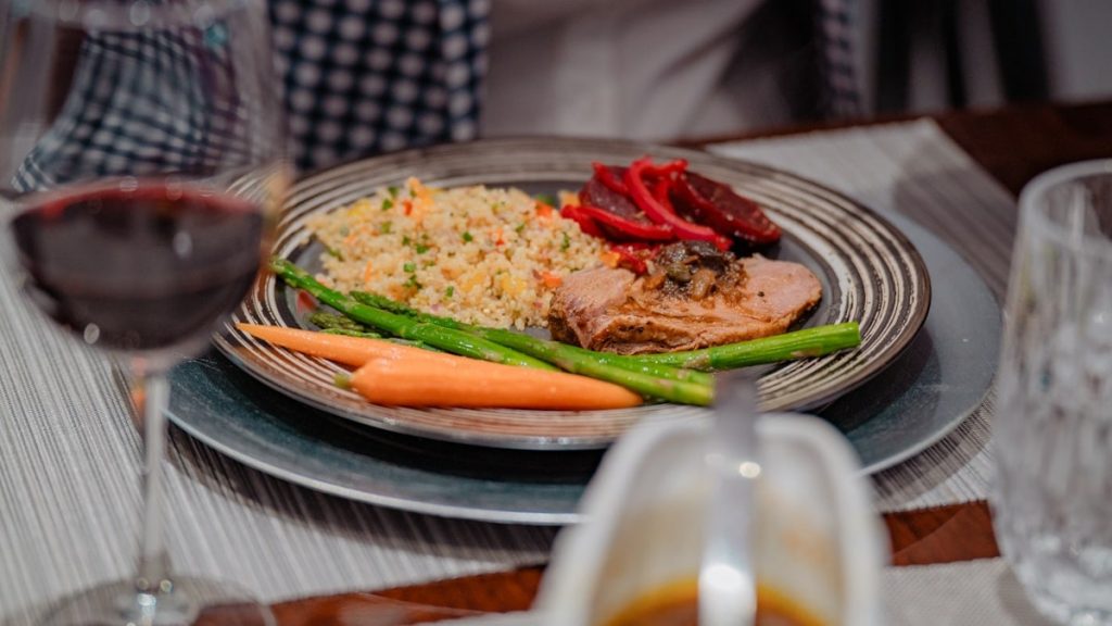 a plate of food on a table with a glass of wine
